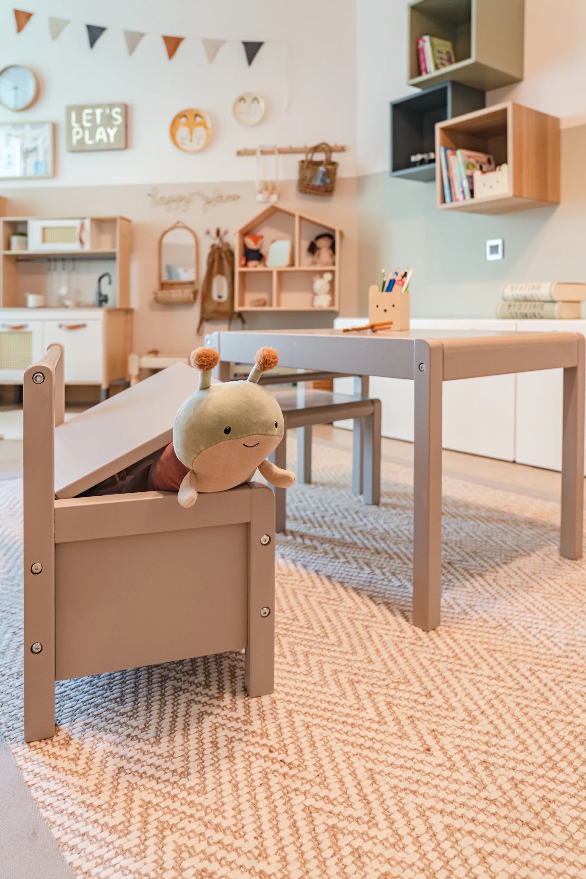 Children's playroom with low timber furniture and a woven herringbone rug